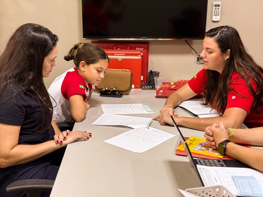 Família acompanhando as conquistas da criança com atenção e orgulho na Maple Bear Mogiana
